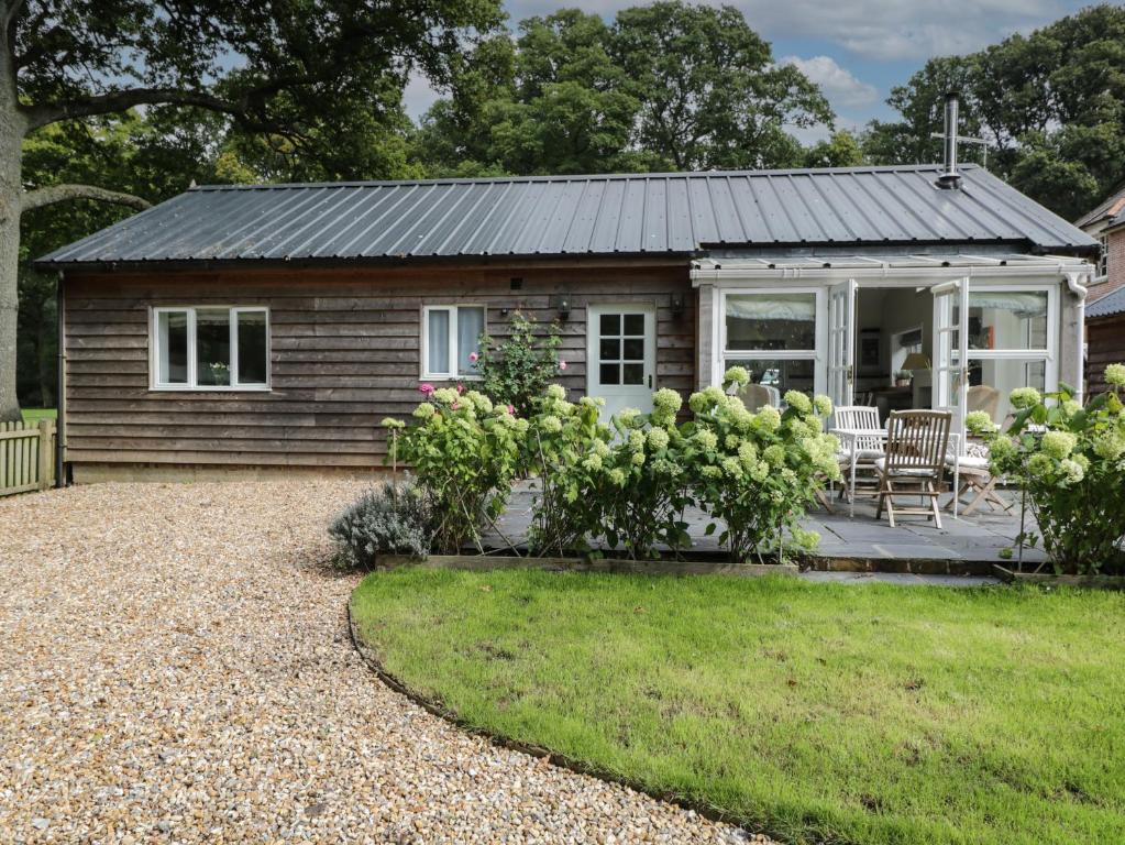 a cottage with a table and chairs in front of it at The Roost in Cheriton