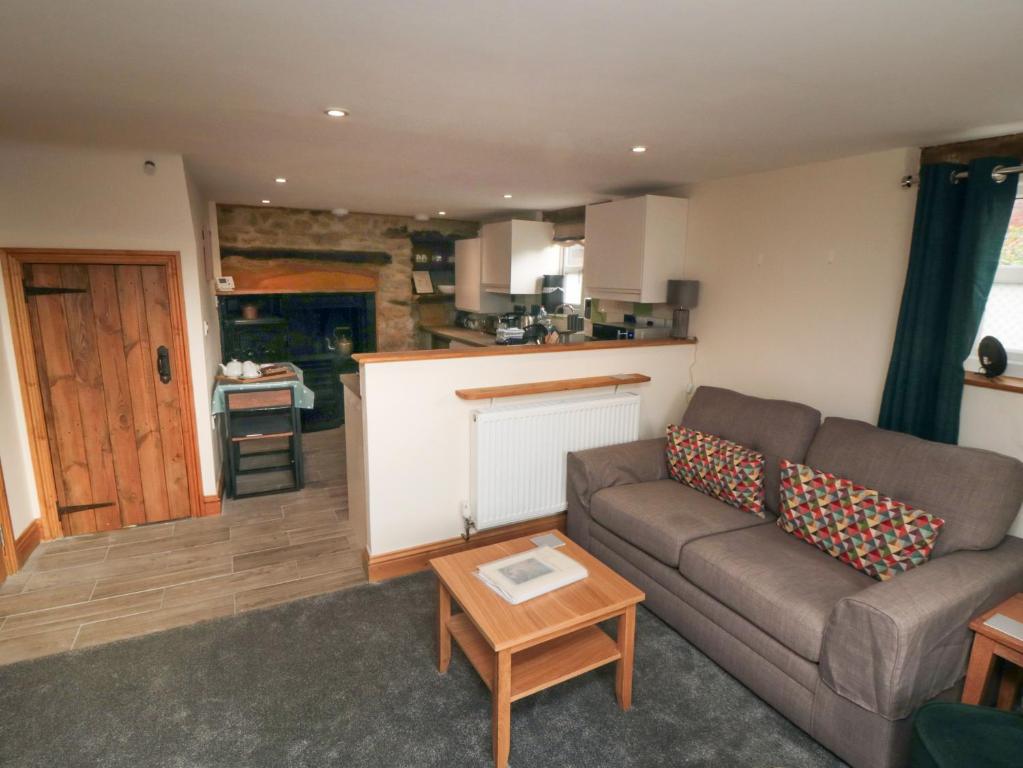 ein Wohnzimmer mit einem Sofa und einem Tisch in der Unterkunft Crumble's Hideaway in York