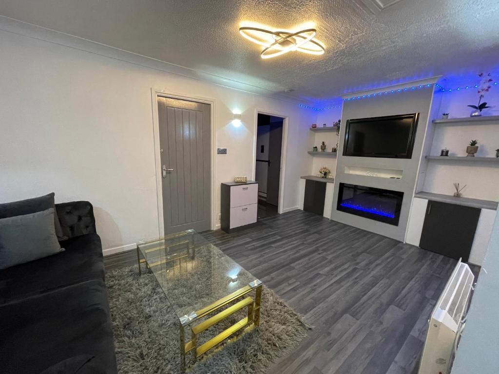 a living room with a couch and a tv at Newly refurbished modern 2 bedroom flat in Trimley Heath