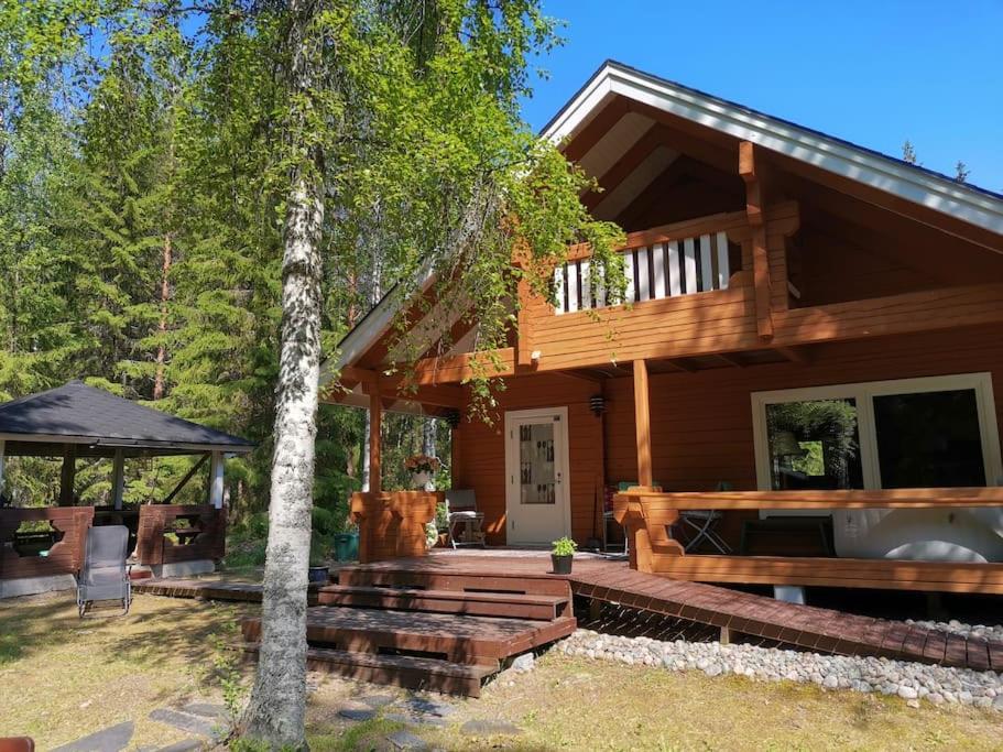 a log home with a porch and a gazebo at Casa di Sanna in Orimattila