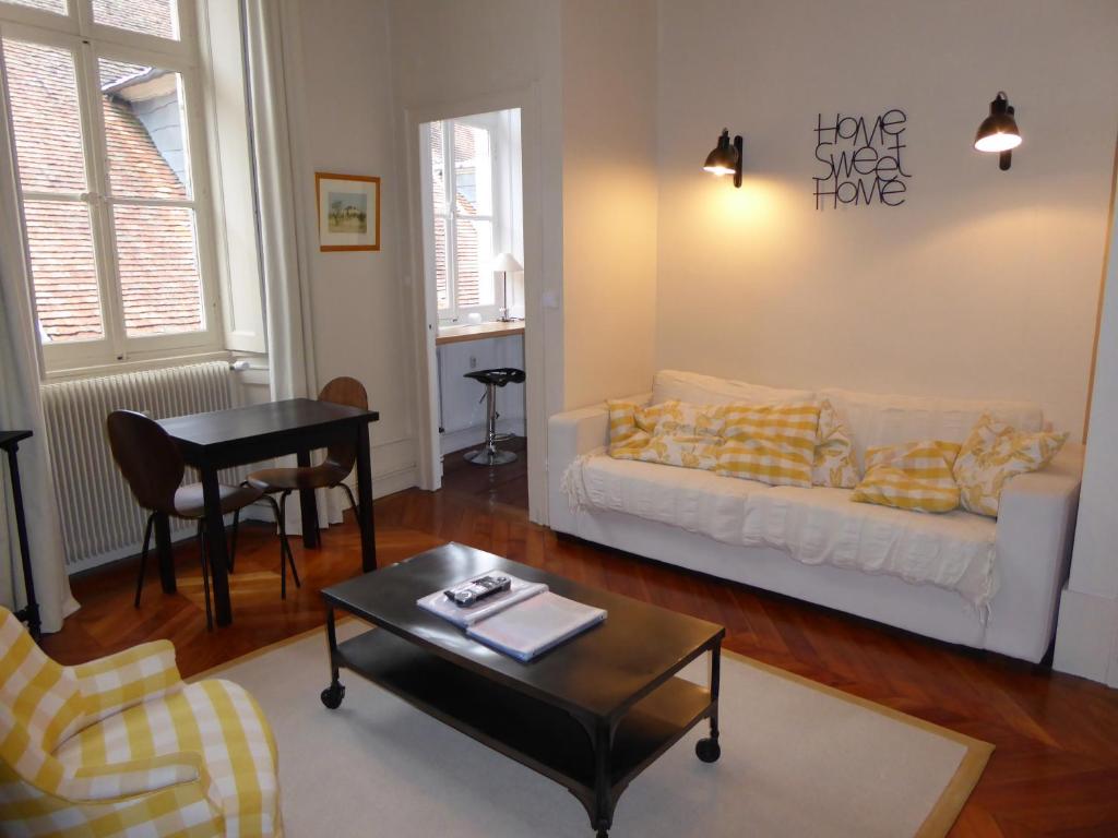 a living room with a couch and a table at L'Annexe Apparthôtel du 11 C, 3 étoiles in Besançon