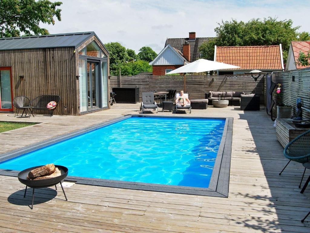 a swimming pool on a wooden deck next to a house at 4 person holiday home in MALM in Malmö