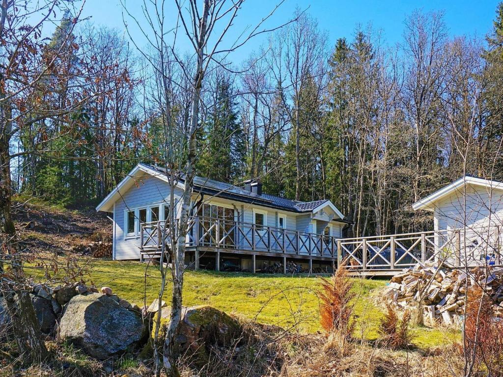 una gran casa blanca en una colina en el bosque en 4 person holiday home in VESTERLANDA, en Västerlanda