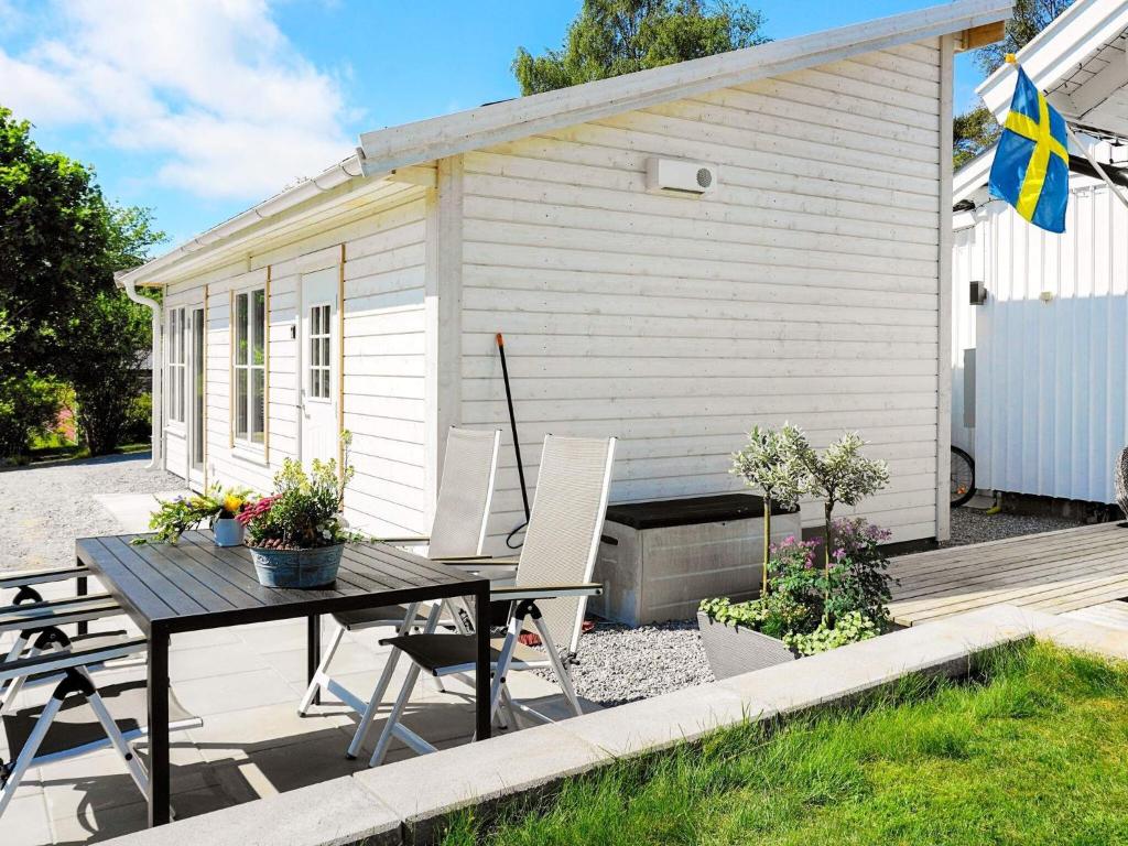 een patio met een tafel en stoelen voor een gebouw bij 5 person holiday home in K LLEK RR in Spjärr