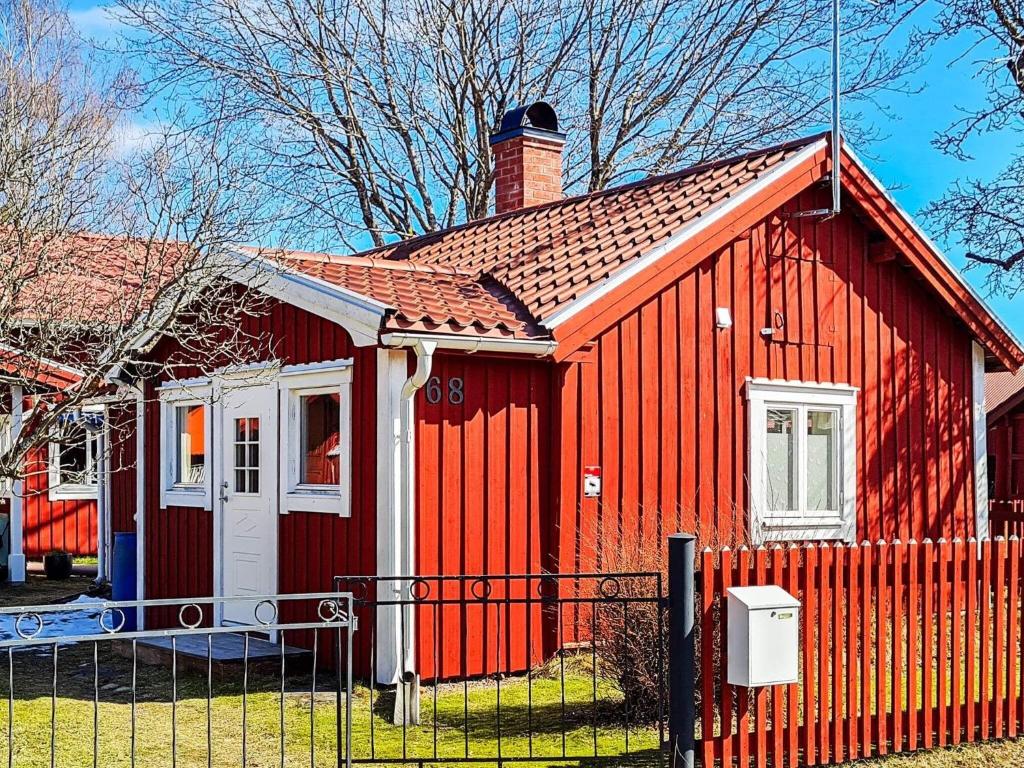 ein rotes Haus mit einem Zaun davor in der Unterkunft Holiday home BORLÄNGE in Borlänge