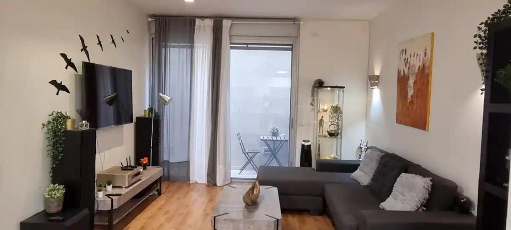 a living room with a couch and a large window at funattlv in Tel Aviv