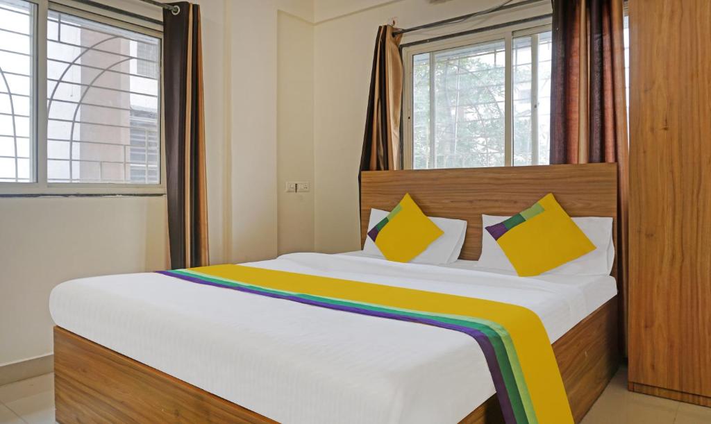 a bedroom with a large bed with a rainbow blanket at Itsy By Treebo - AY Plus Hotels in Kharadi