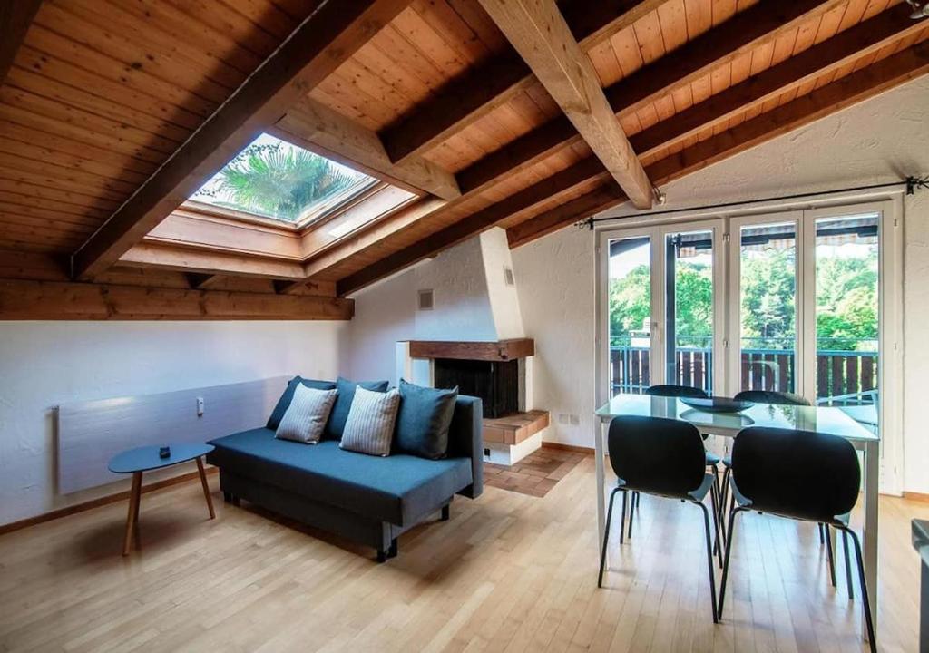 uma sala de estar com um sofá azul e uma mesa em Casa Rogoria - Intimo rifugio con terrazza e caminetto em Astano