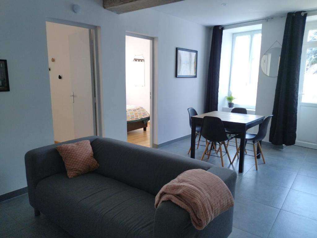 sala de estar con sofá y mesa en La Petite Florentine, en Saint-Florent-le-Vieil