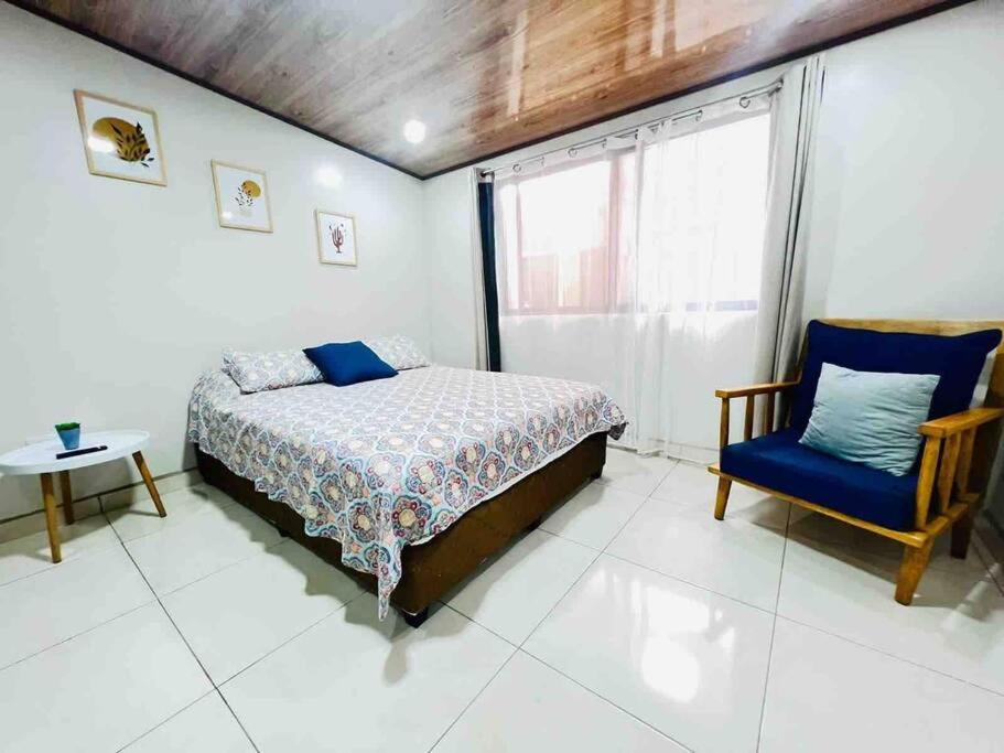 1 dormitorio con 1 cama, 1 silla y 1 ventana en Departamento H González 2, en El Coco