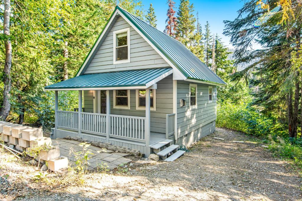 a tiny house with a porch in the woods at Snowdrop Summit Cabin in Snoqualmie Pass