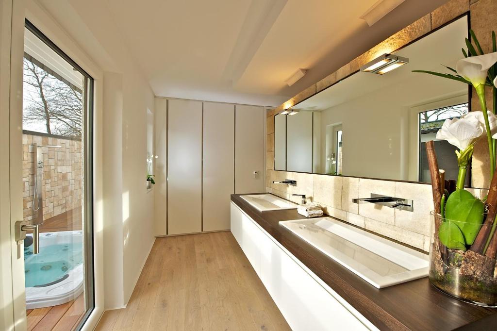 a bathroom with two sinks and a large mirror at Designer-Loft mit Whirlpool in Cologne