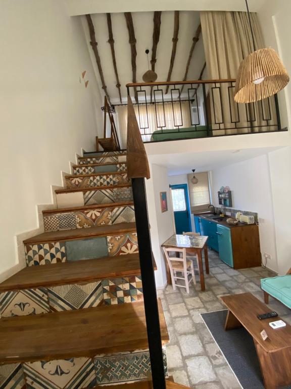 Sunside Inn Hotel في كيرينيا: غرفة بها درج ومطبخ مع طاولة