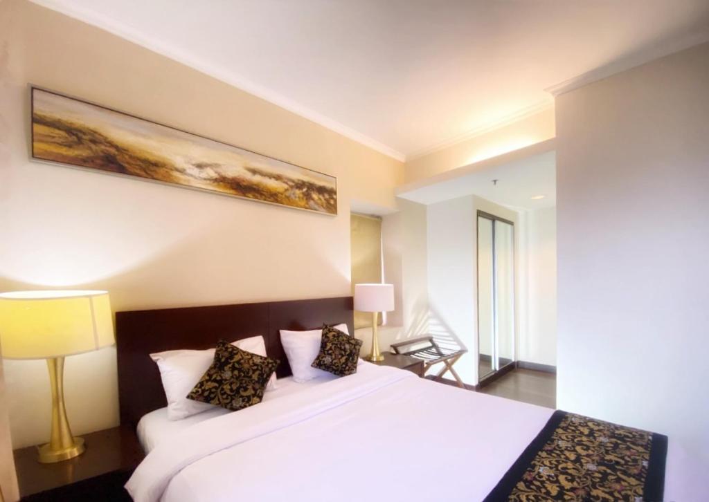sypialnia z dużym białym łóżkiem z 2 poduszkami w obiekcie Ancol Marina Residence w Dżakarcie