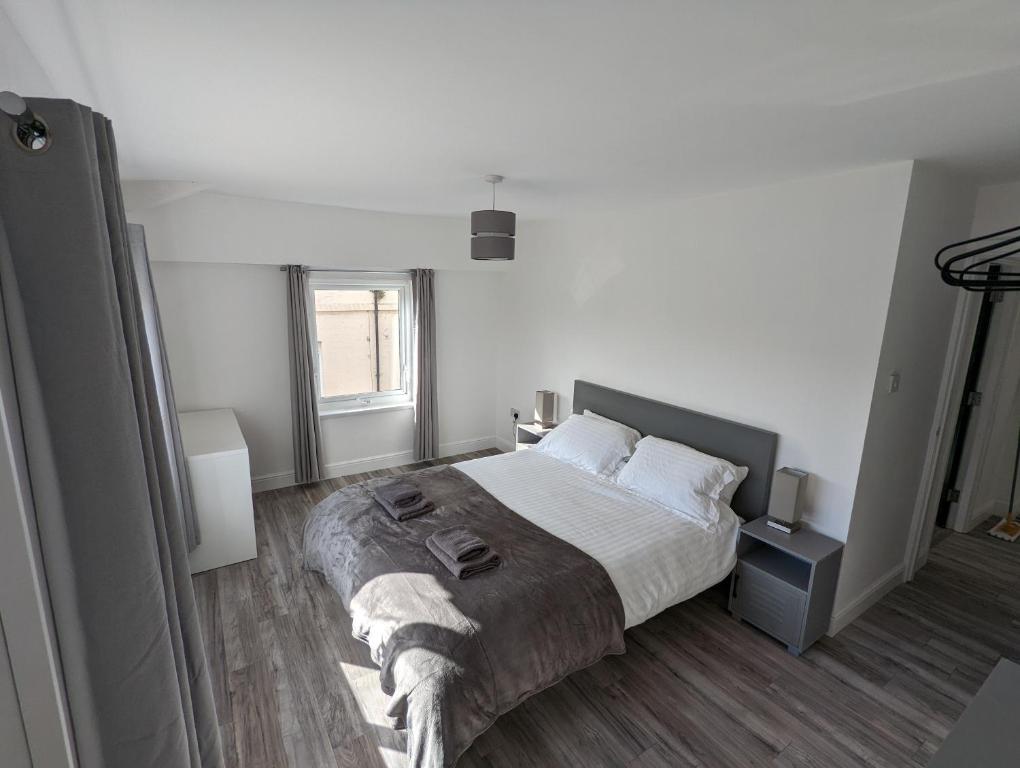 1 dormitorio con 1 cama grande con sábanas y almohadas blancas en Windsor Stays 2 en Liverpool