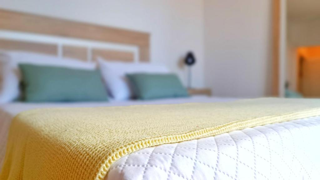 zbliżenie łóżka z żółtym kocem w obiekcie Ático Deluxe Granada, Parking gratis y Terraza w mieście Armilla