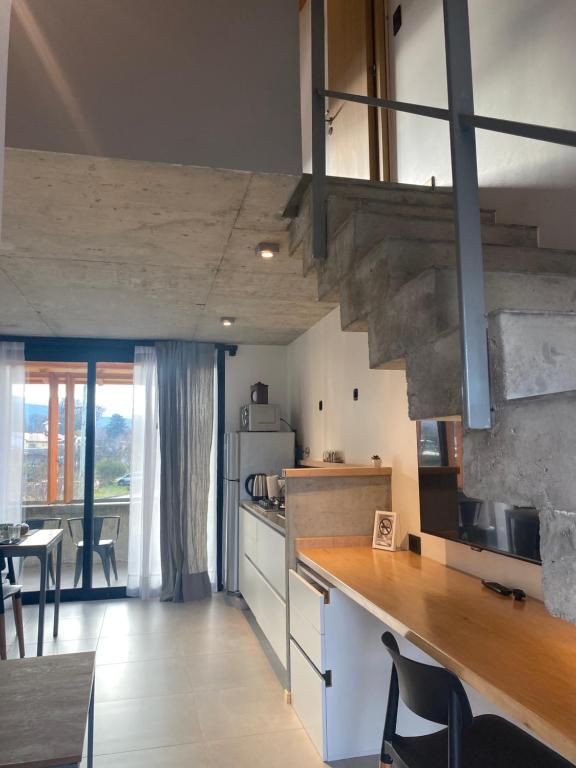 a large kitchen with a counter and a dining room at ENTREVERDES Departamentos in El Bolsón