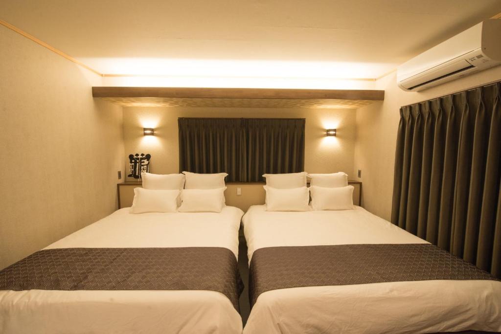 two beds in a hotel room with white pillows at Izumo - House - Vacation STAY 13870v in Izumo