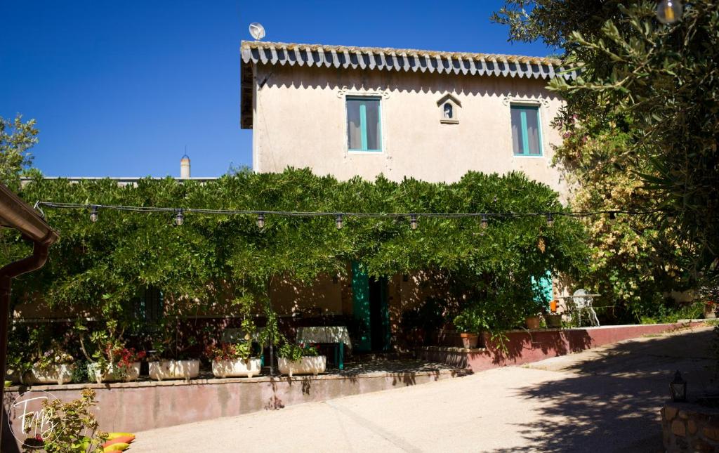 Un bâtiment avec quelques arbres devant lui dans l'établissement Corte Boero Bed&Breakfast, à Capoterra