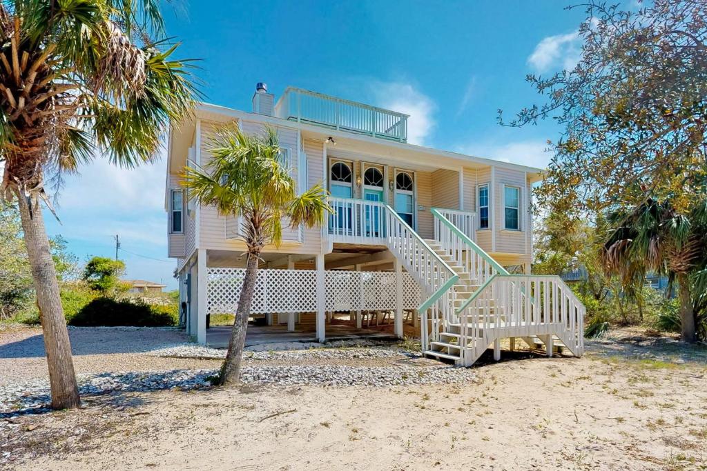a large yellow house with stairs on the beach at Southern Belle in St. George Island