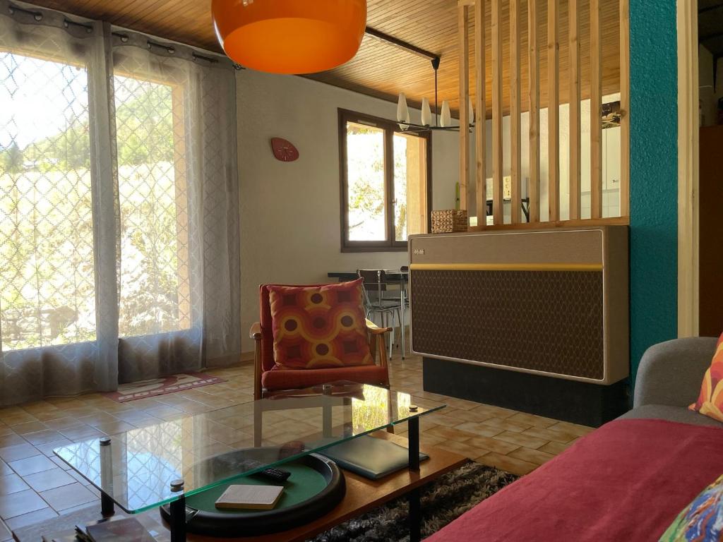 un salon avec un canapé et une chaise dans l'établissement Vénosc-Les 2 Alpes , Rez de jardin, à Vénosc