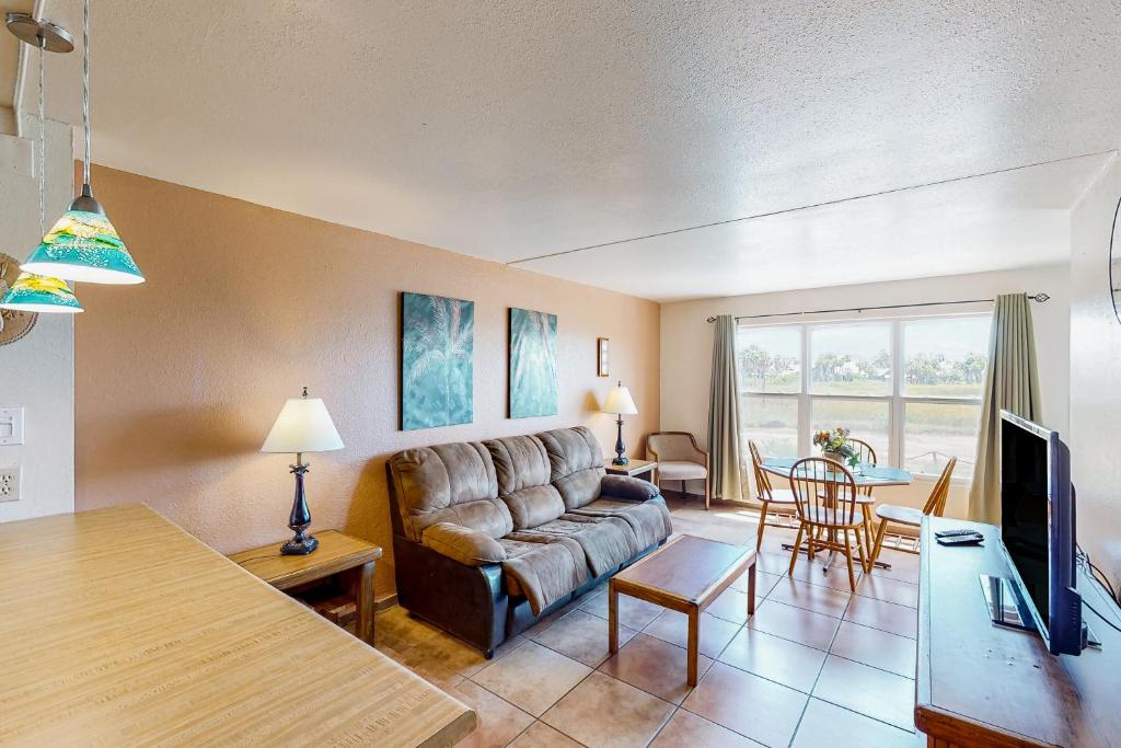 uma sala de estar com um sofá e uma mesa em Gulfview I #207 em South Padre Island