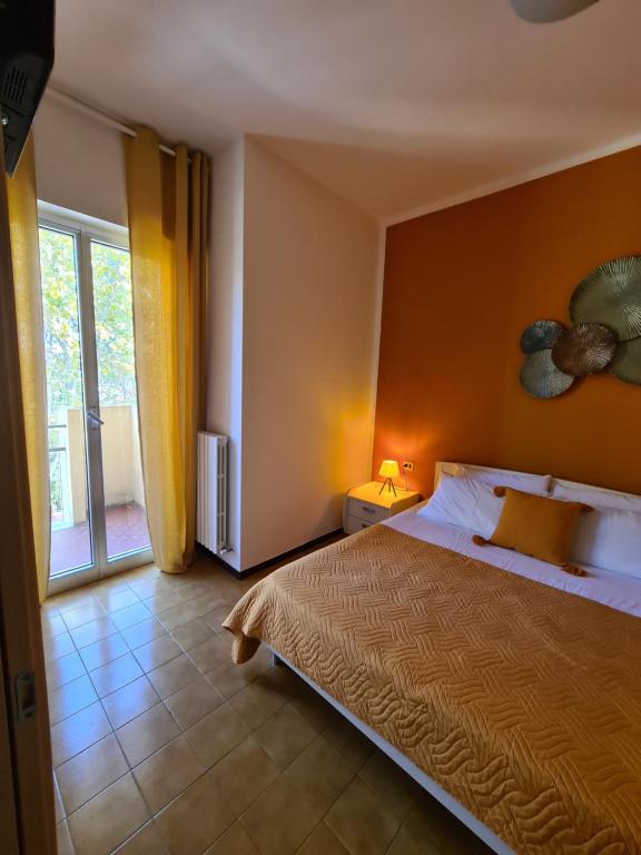 sypialnia z łóżkiem i dużym oknem w obiekcie Terrazza vicino al mare w Rimini