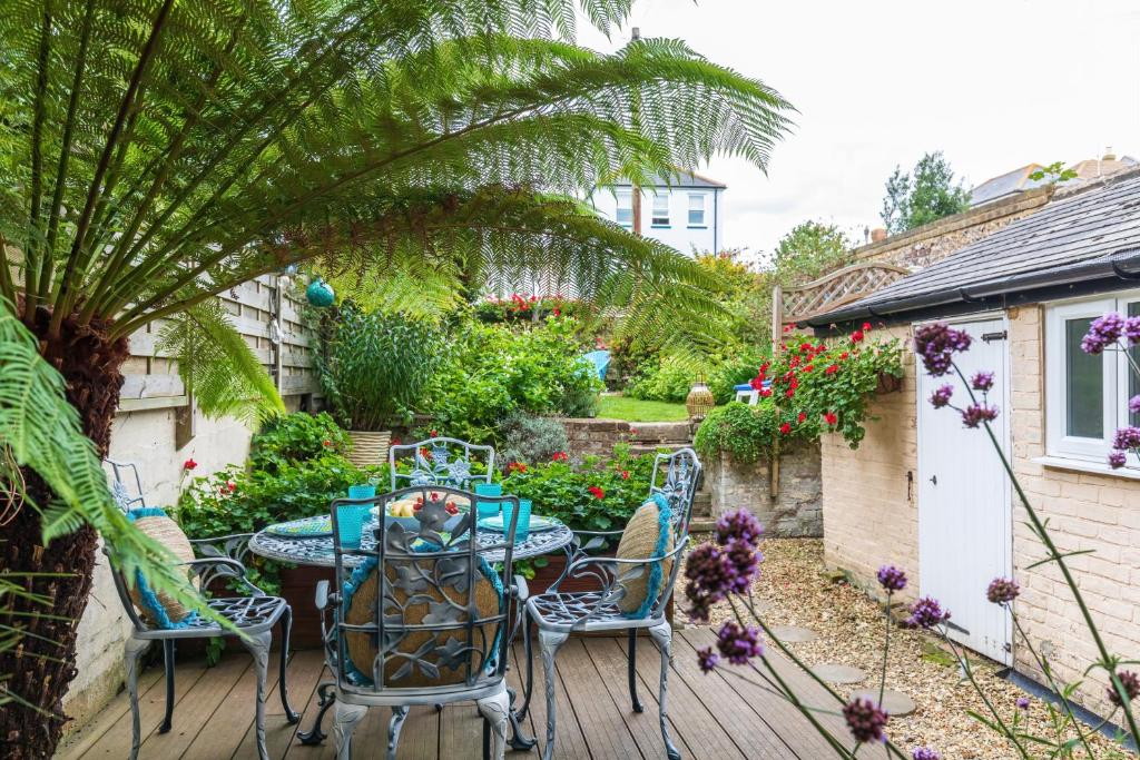 a patio with a table and chairs in a garden at Seafront Apartment Private Garden & Free Parking in Littlehampton