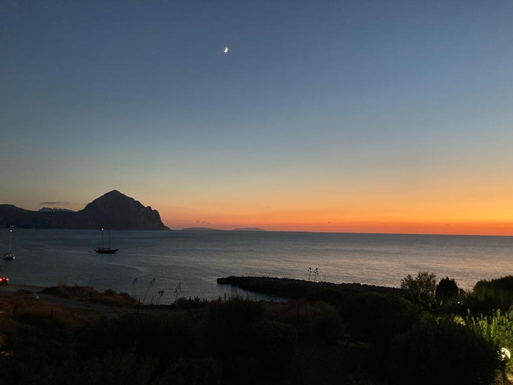a sunset over the ocean with a boat in the water at Paradiso Isulidda in Macari
