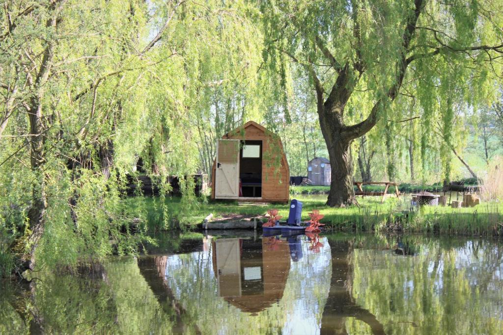 a small cabin in the middle of a body of water at Rum Bridge 'Willows' Glamping Pod in Clare