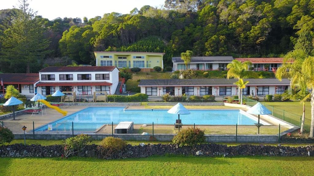 a large swimming pool with a slide in a resort at Haruru Falls Motel & Conference Centre in Paihia