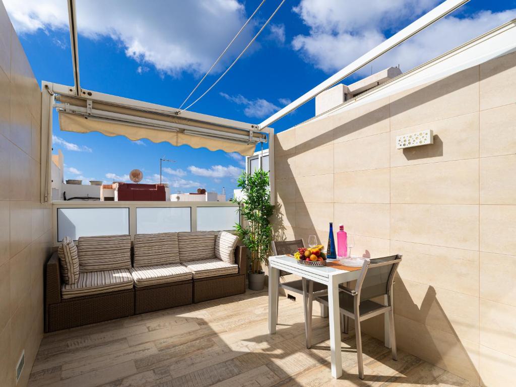 einen kleinen Balkon mit einem Tisch und einer Bank in der Unterkunft Attico Albareda in Las Palmas de Gran Canaria