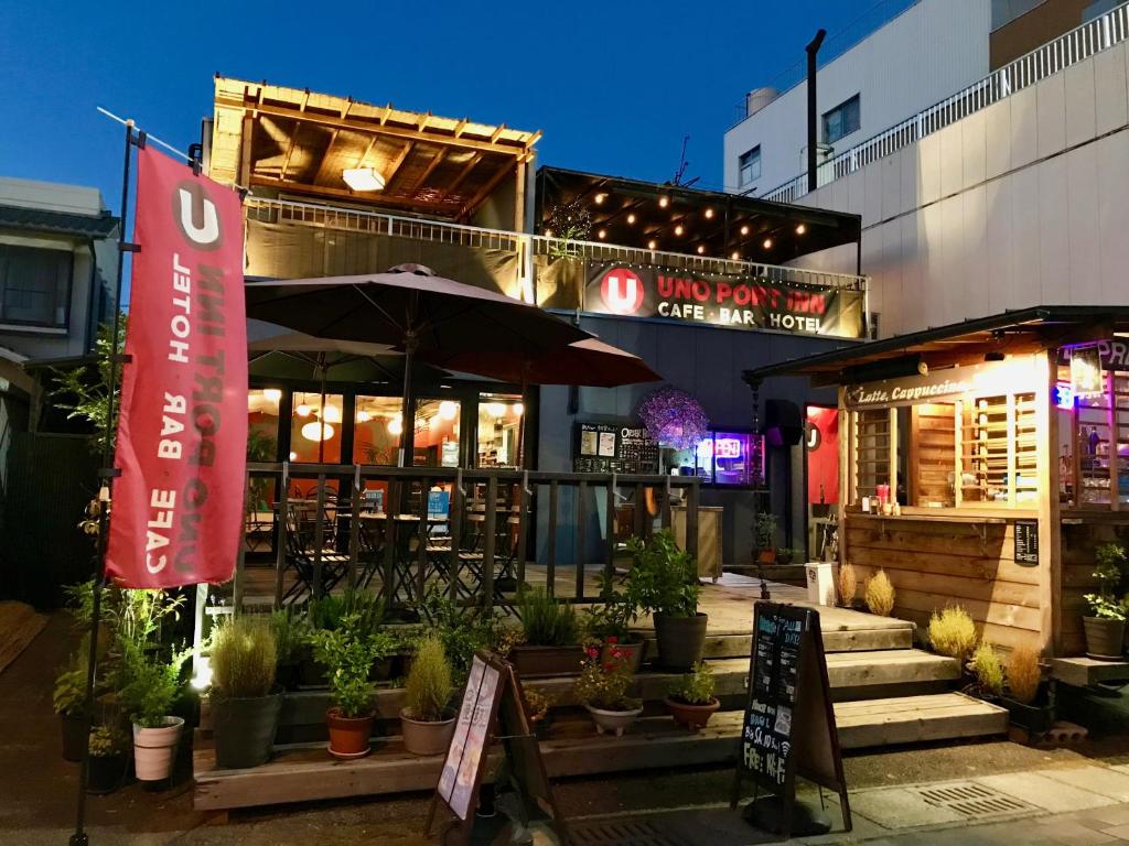 a restaurant with potted plants in front of a building at Uno Port Inn in Tamano