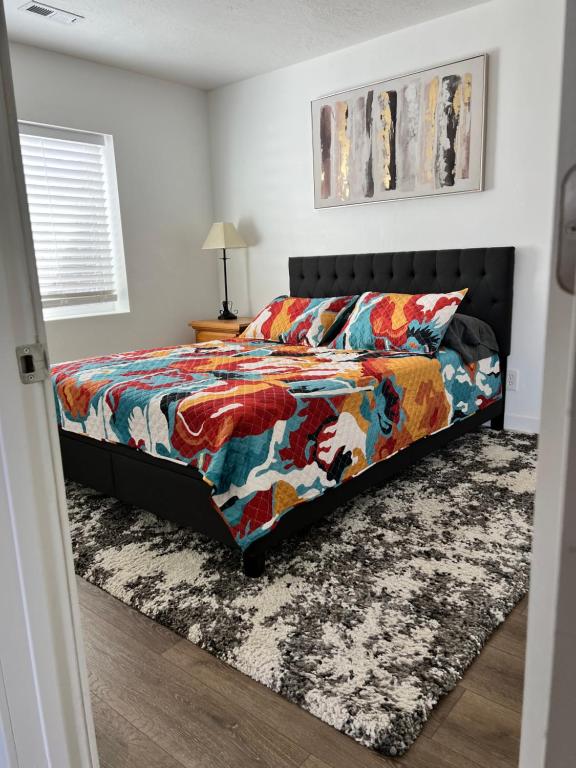 een slaapkamer met een bed met een kleurrijk dekbed bij Perfect Little Place in Tooele
