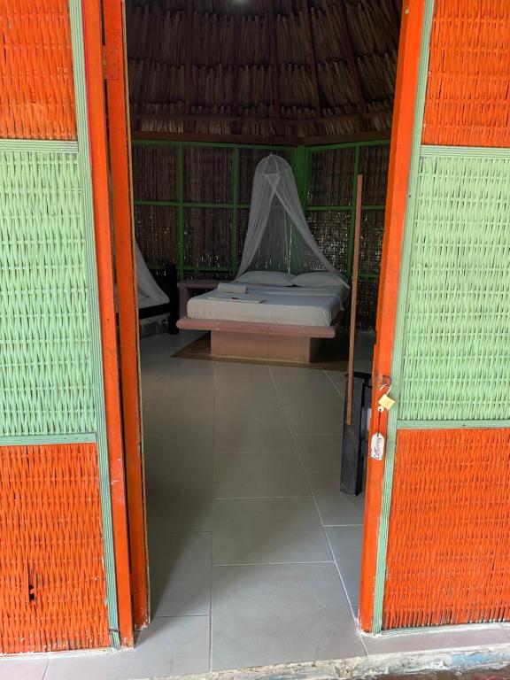 an open door to a bed in a tent at Eco Hotel Las Palmeras in Isla Grande