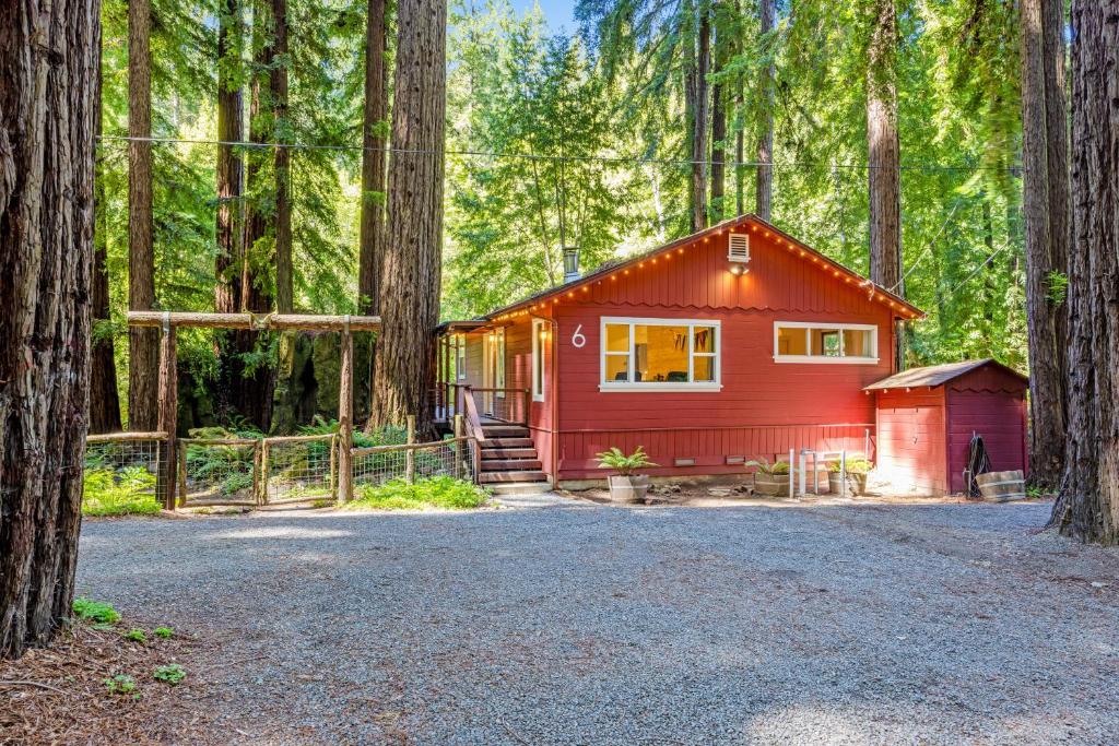 uma cabana vermelha no meio de uma floresta em Caz Cabin 6 em Cazadero