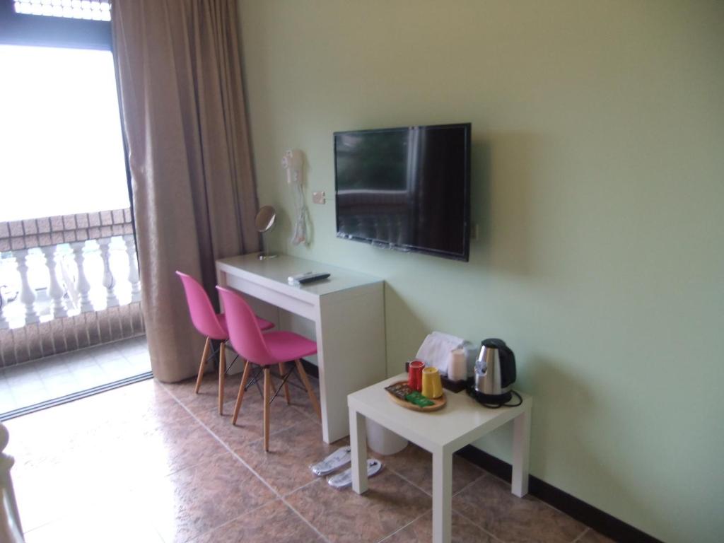 a room with a desk and a tv on a wall at Jiufen Hui Ming Homestay in Jiufen