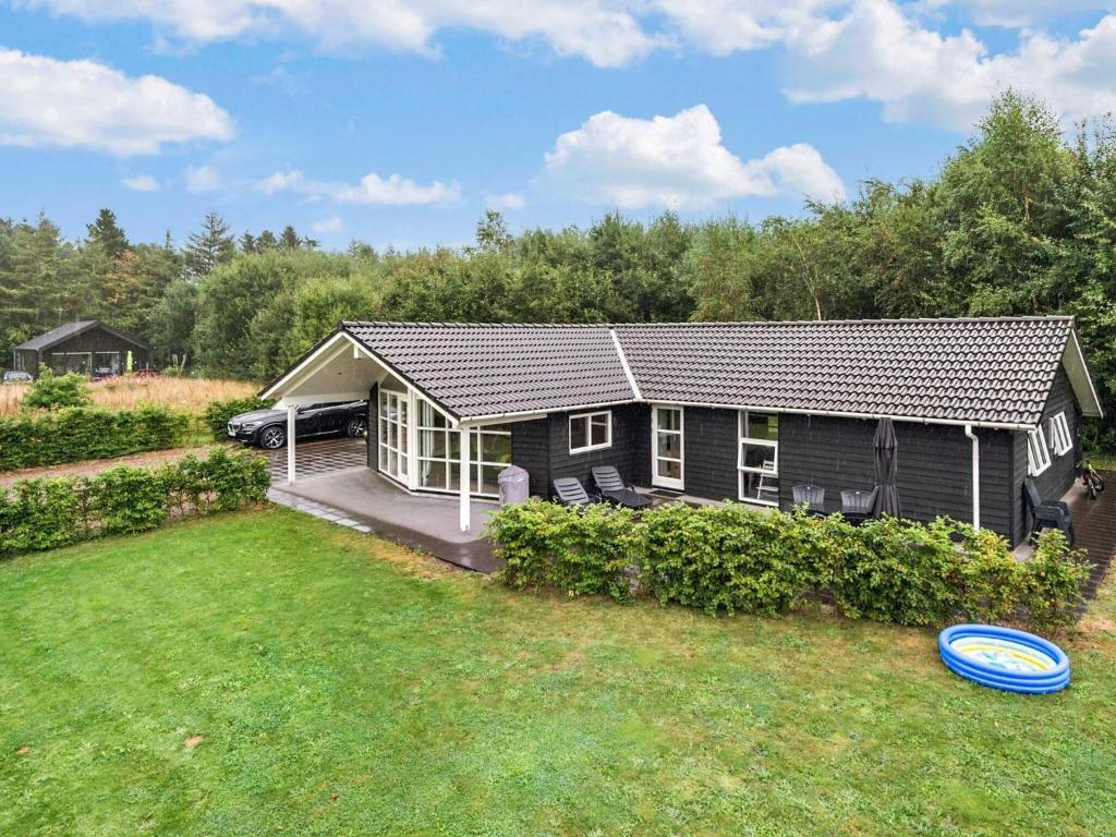 ein kleines Haus mit einem blauen Frisbee im Hof in der Unterkunft Holiday home Ansager XXII in Ansager