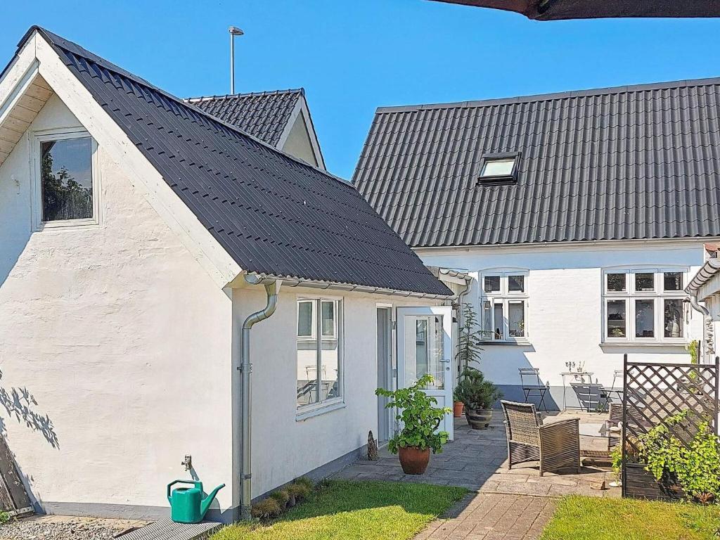 uma casa branca com um telhado preto em 6 person holiday home in Frederikshavn em Frederikshavn