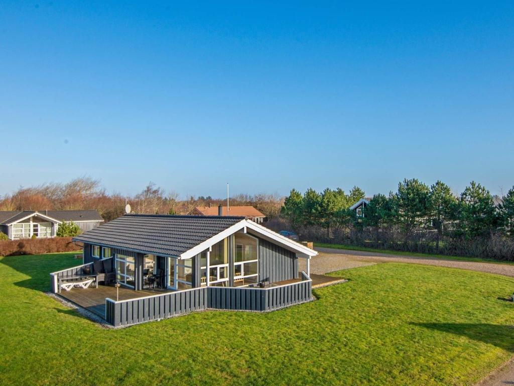 a large house with a roof on a grass field at 6 person holiday home in Tarm in Tarm