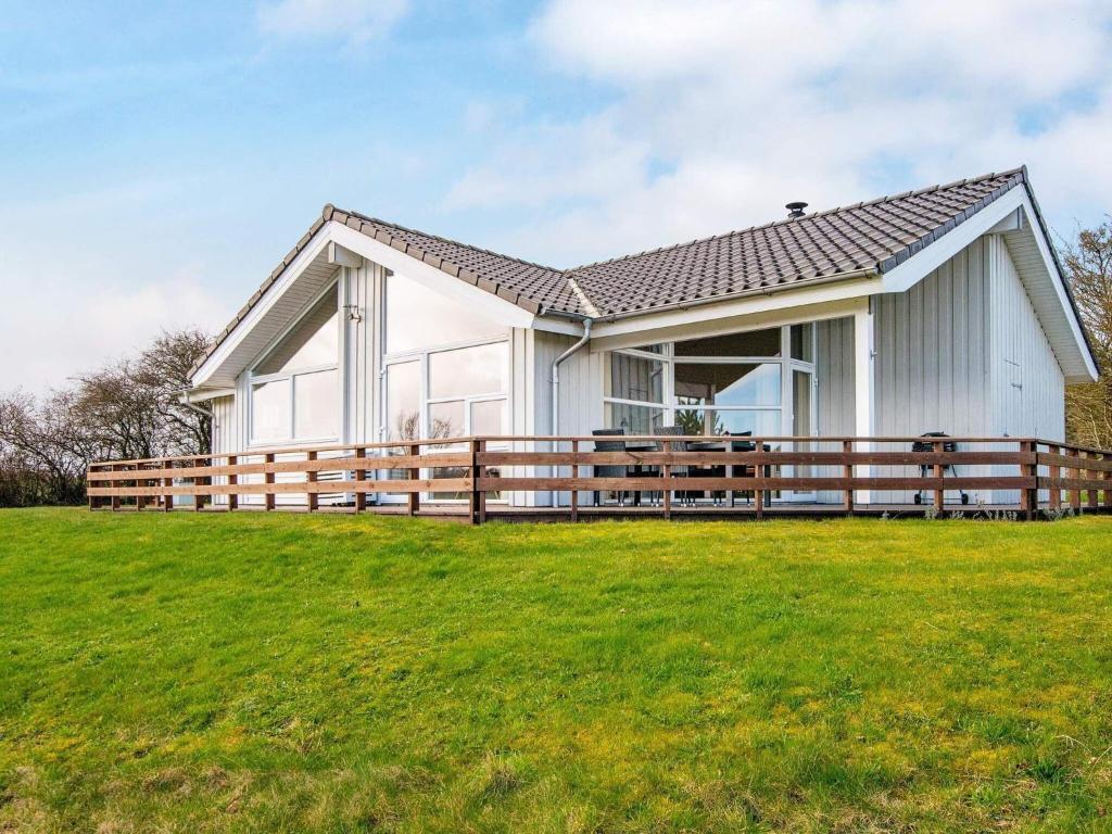 una casa blanca con una valla de madera en un campo en Holiday home Nordborg XVIII, en Nordborg