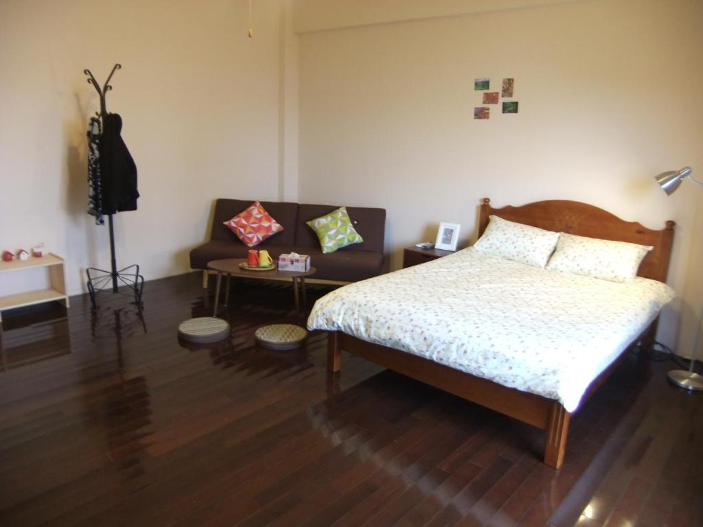a bedroom with a bed and a couch at Jiufen Hui Ming Homestay in Jiufen