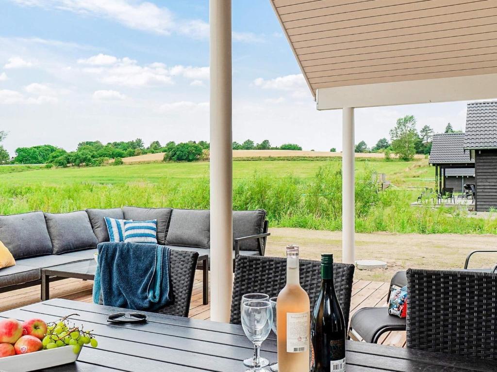 einen Tisch mit einer Flasche Wein auf einer Terrasse in der Unterkunft 14 person holiday home in Vejby in Vejby