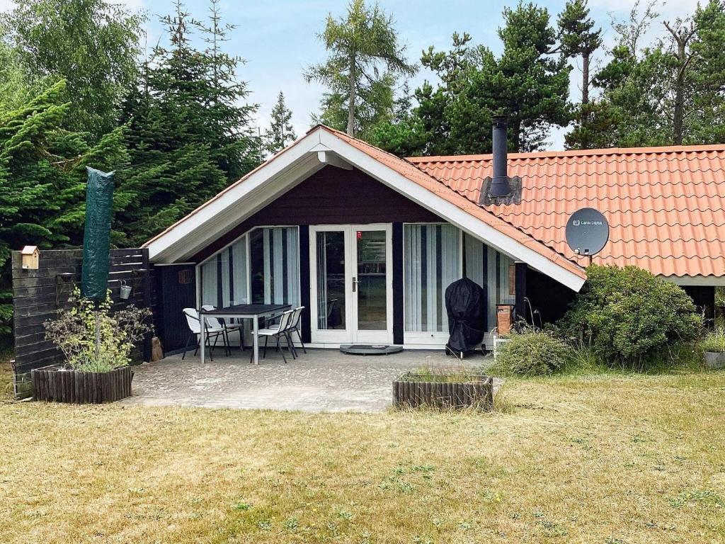 a small house with a patio and a table at Holiday home Væggerløse CCXIII in Marielyst