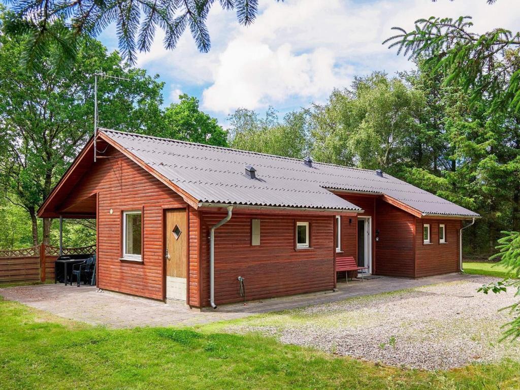 Thyholmにある6 person holiday home in Thyholmの木々が茂る公園内の小さな木造キャビン