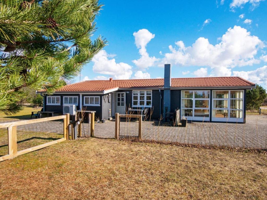 ein Haus mit einem Zaun davor in der Unterkunft 6 person holiday home in Ulfborg in Ulfborg