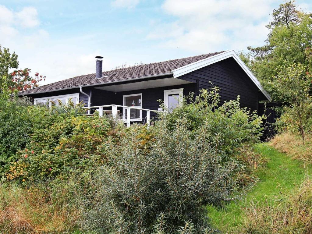 a black house sitting on top of a hill at Two-Bedroom Holiday home in Kalundborg 1 in Bjørnstrup