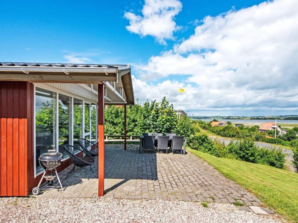 a house with a patio and a grill at Holiday home Hejls LVI in Hejls