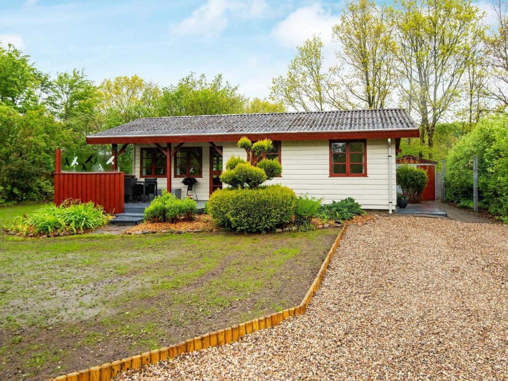 una pequeña casa blanca con una valla roja en 4 person holiday home in Toftlund, en Toftlund