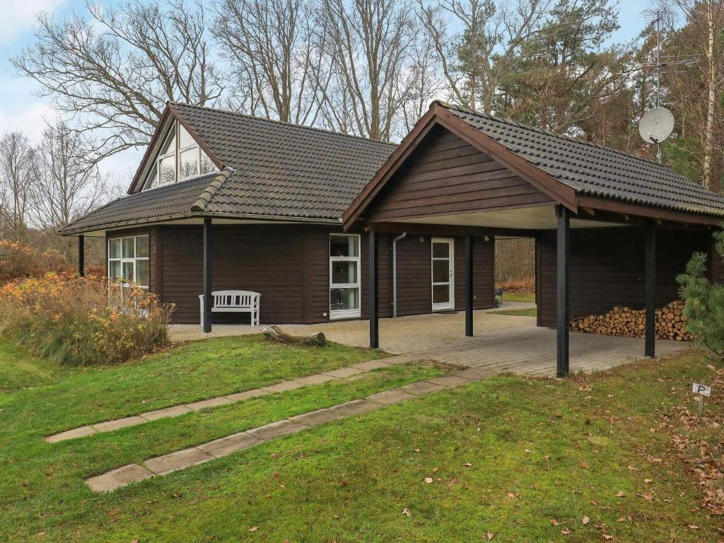 uma pequena casa com um banco à frente em Holiday home Læsø XX em Læsø